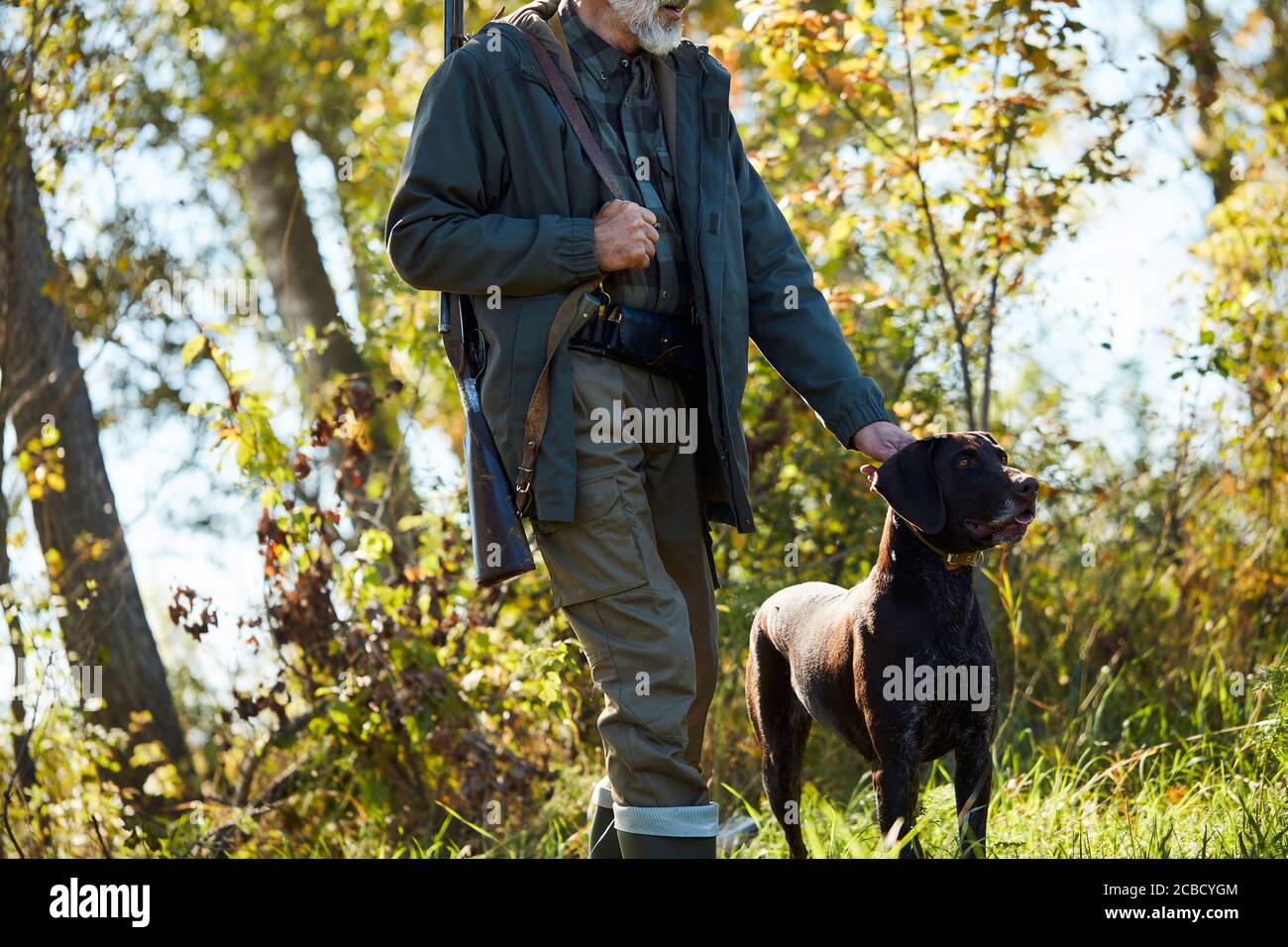 man with black labrador retriever with all equipment go hunting. Active hunting time Stock Photo