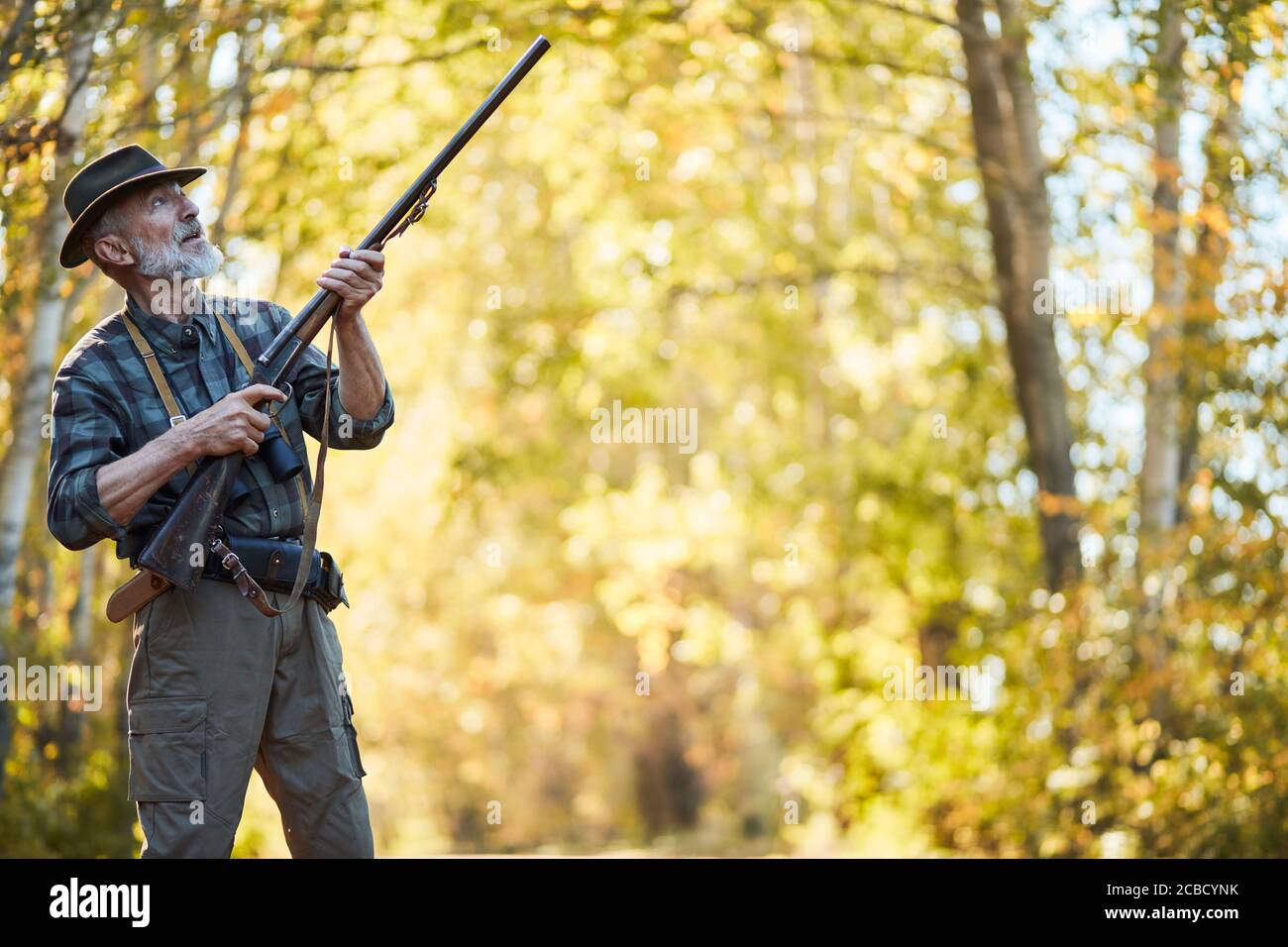 Hunting on wild birds in forest. Caucasian senior man hunt on birds