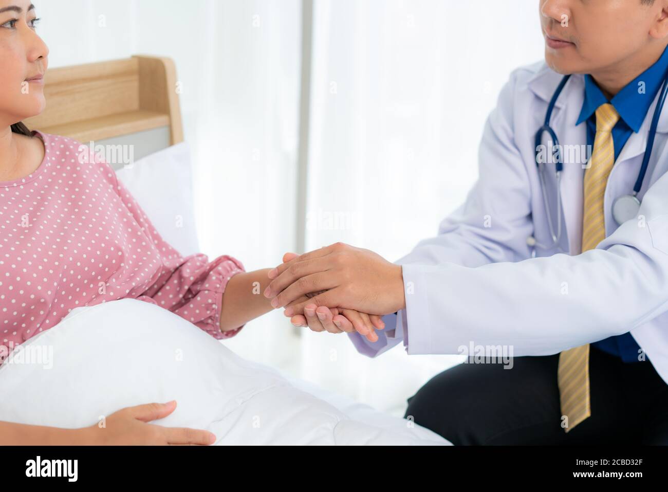 Close up of man doctor touching patient hand for encouragement and empathy on the hospital, cheering and support patient, Bad news, medical examinatio Stock Photo