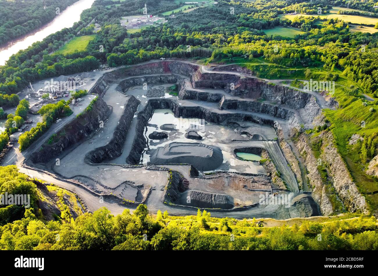 Aerial view of opencast mining quarry in the middle of the forest