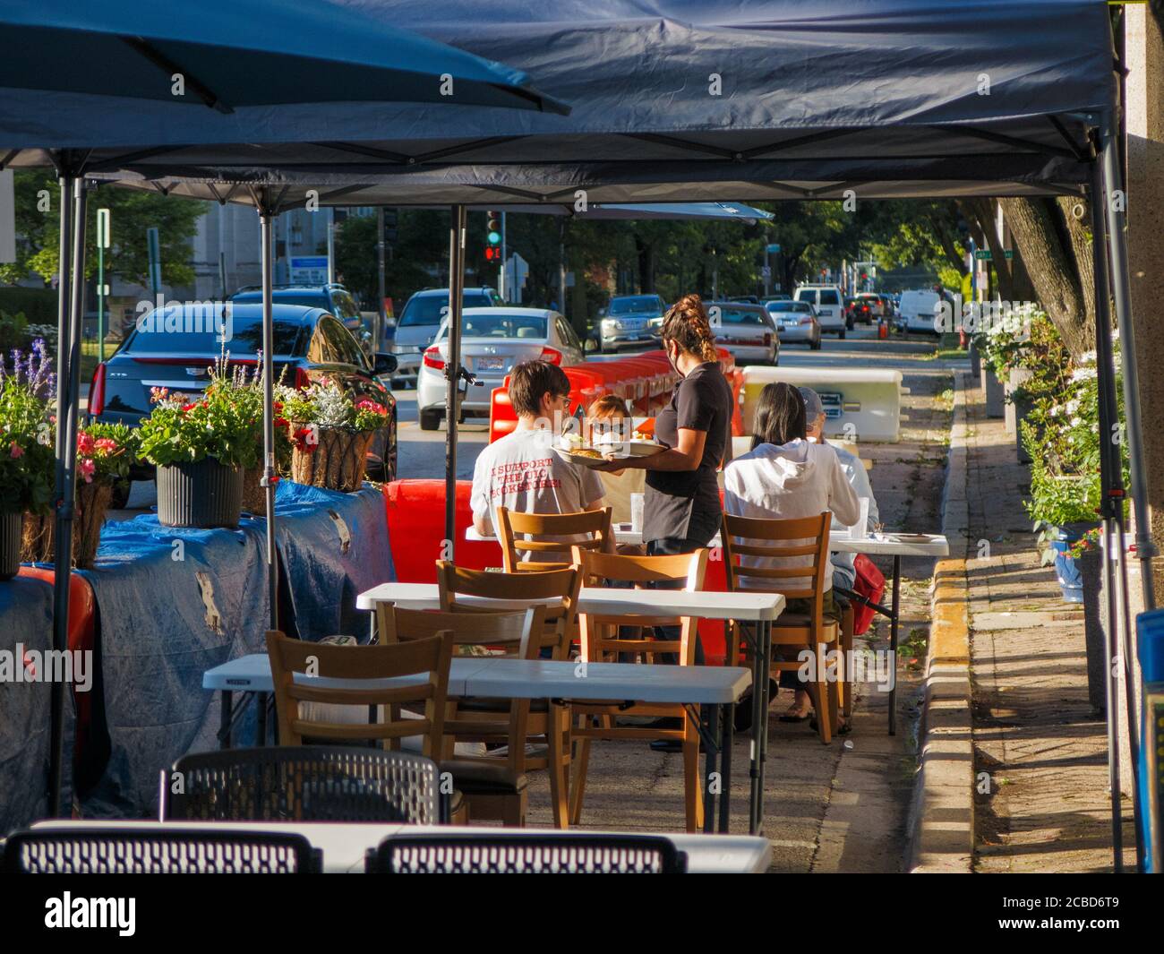 Outdoor restaurant eating area in Oak Park Avenue protected by water-filled jersey barriers during COVID-19 pandemic. Oak Park, Illinois Stock Photo