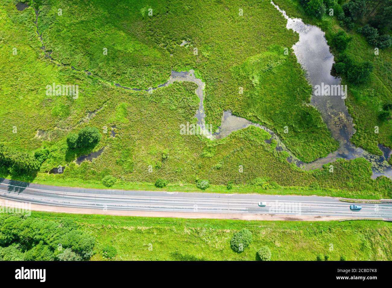 green countryside with small river and road. rural landscape on summer sunny day. aerial photo Stock Photo