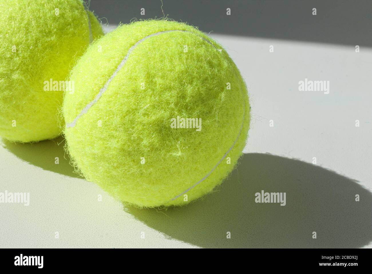 Two golden tennis balls on a white background Stock Photo