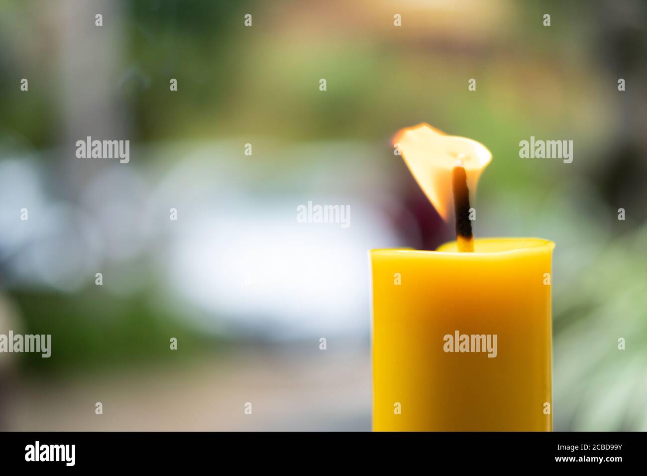 Light flame candle burning brightly on blurred background Stock Photo