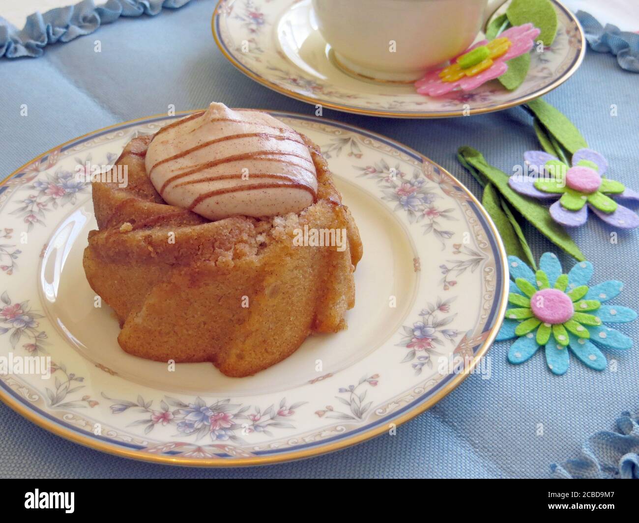Small cake with frosting on a small china plate Stock Photo