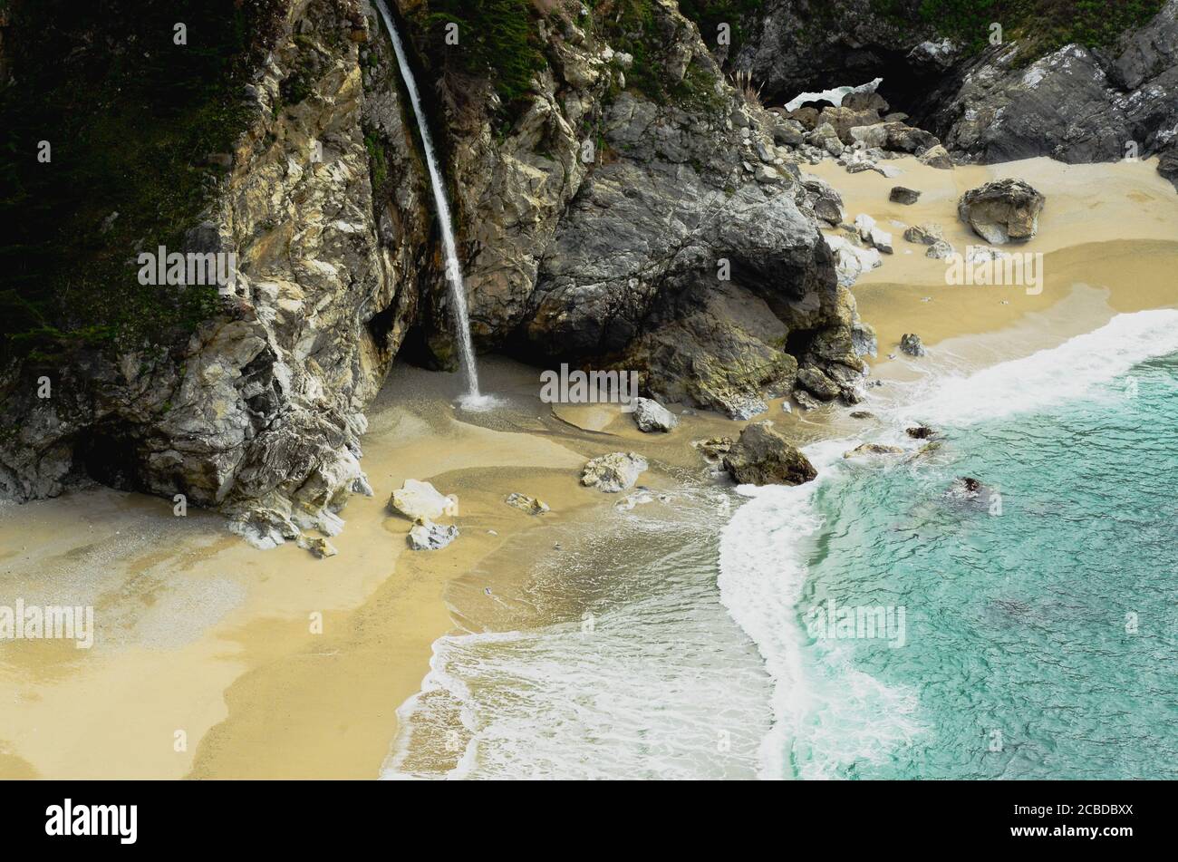 McWay Fall, natural waterfall flows ito  the pacific ocean, colorful beach, rocks, falls and vegetation, makes a vivid -unique landscape, big Sur area. Stock Photo