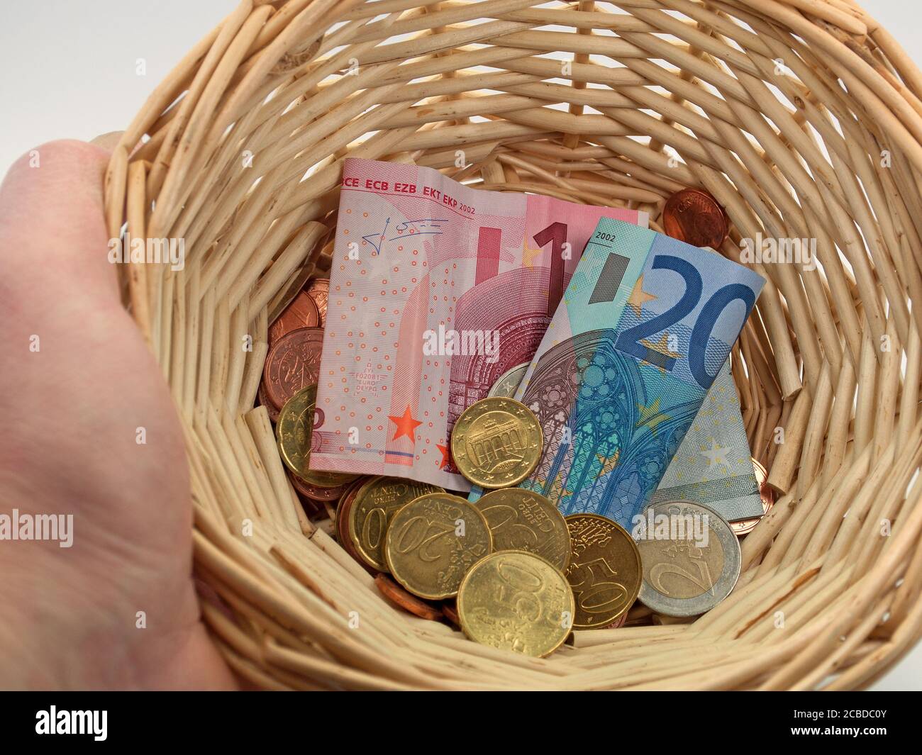 Hand with donation basket with collected money Stock Photo