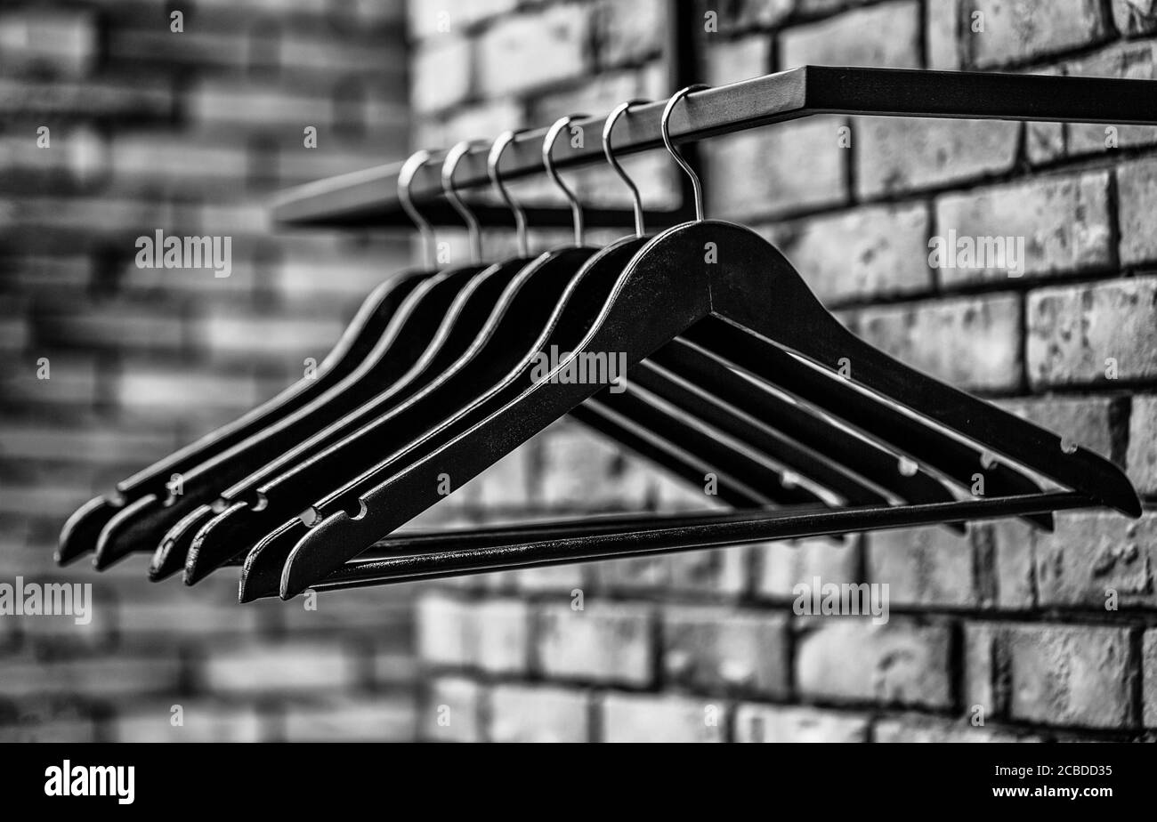 Wooden coat hanger clothes. Fashionable different types of hanger. Many wooden black hangers on a rod. Store concept, sale, design, empty hangers Stock Photo
