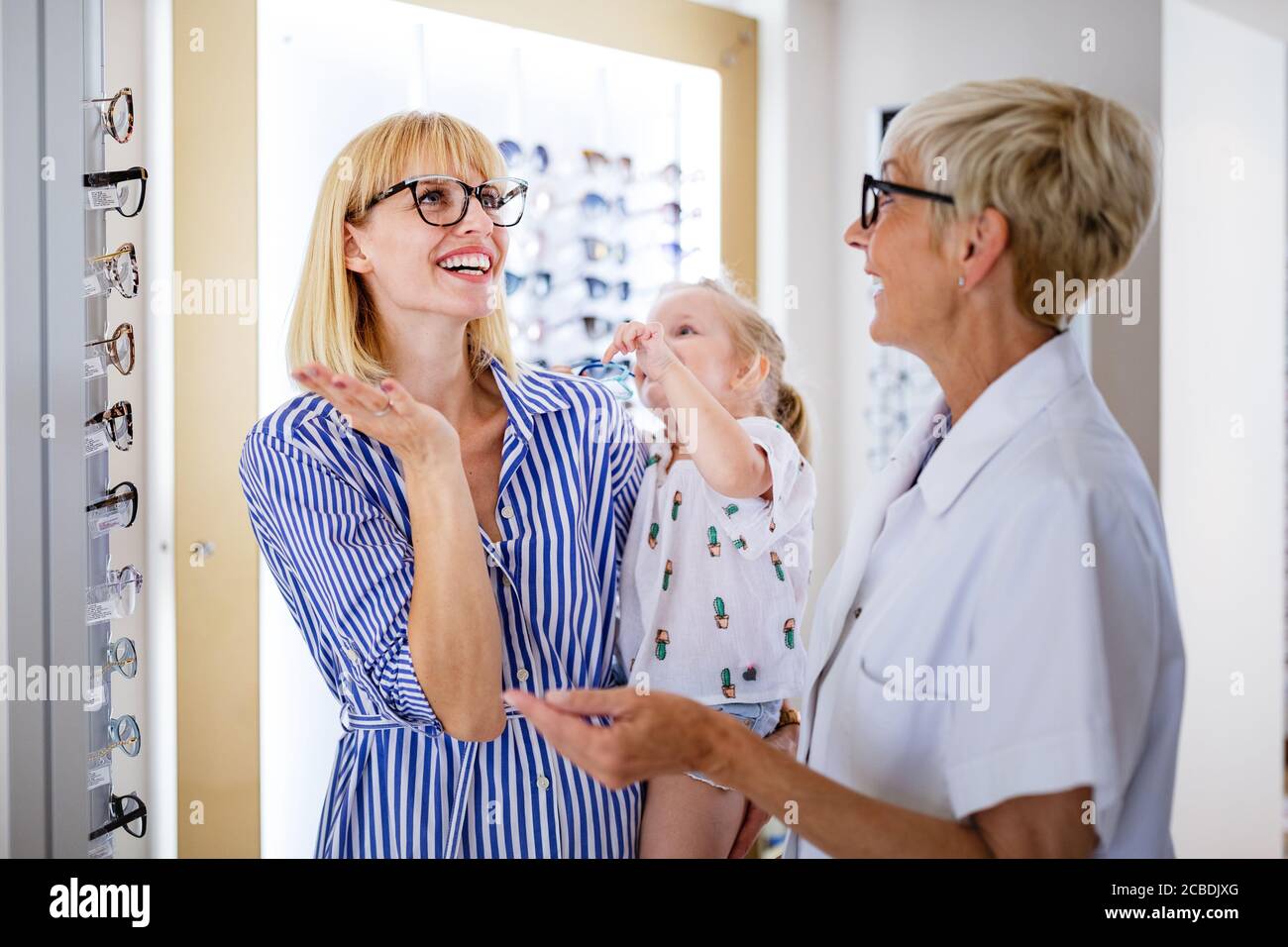 Mother and daughter in optician shop buying eyeglasses Stock Photo
