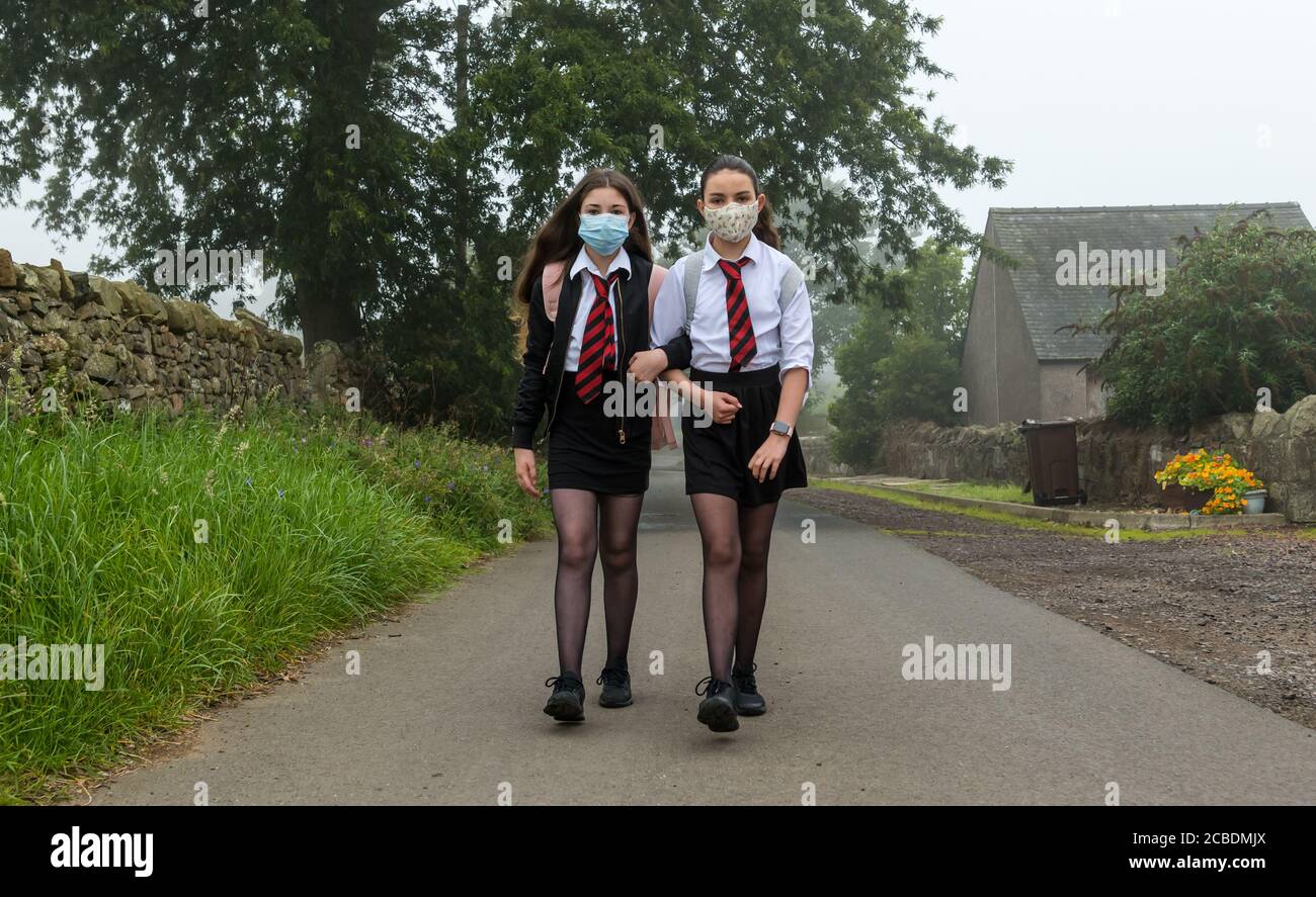 Camptoun, East Lothian, Scotland, United Kingdom, 13 August 2020. Return to school: Twins Louisa and Imogen, who turned 12 years old two days ago, set off from their home on a murky morning for their first day of secondary school at North Berwick High as S1 pupils. They missed out on the normal Induction Days in P7 due to the Covid-19 pandemic lockdown Stock Photo