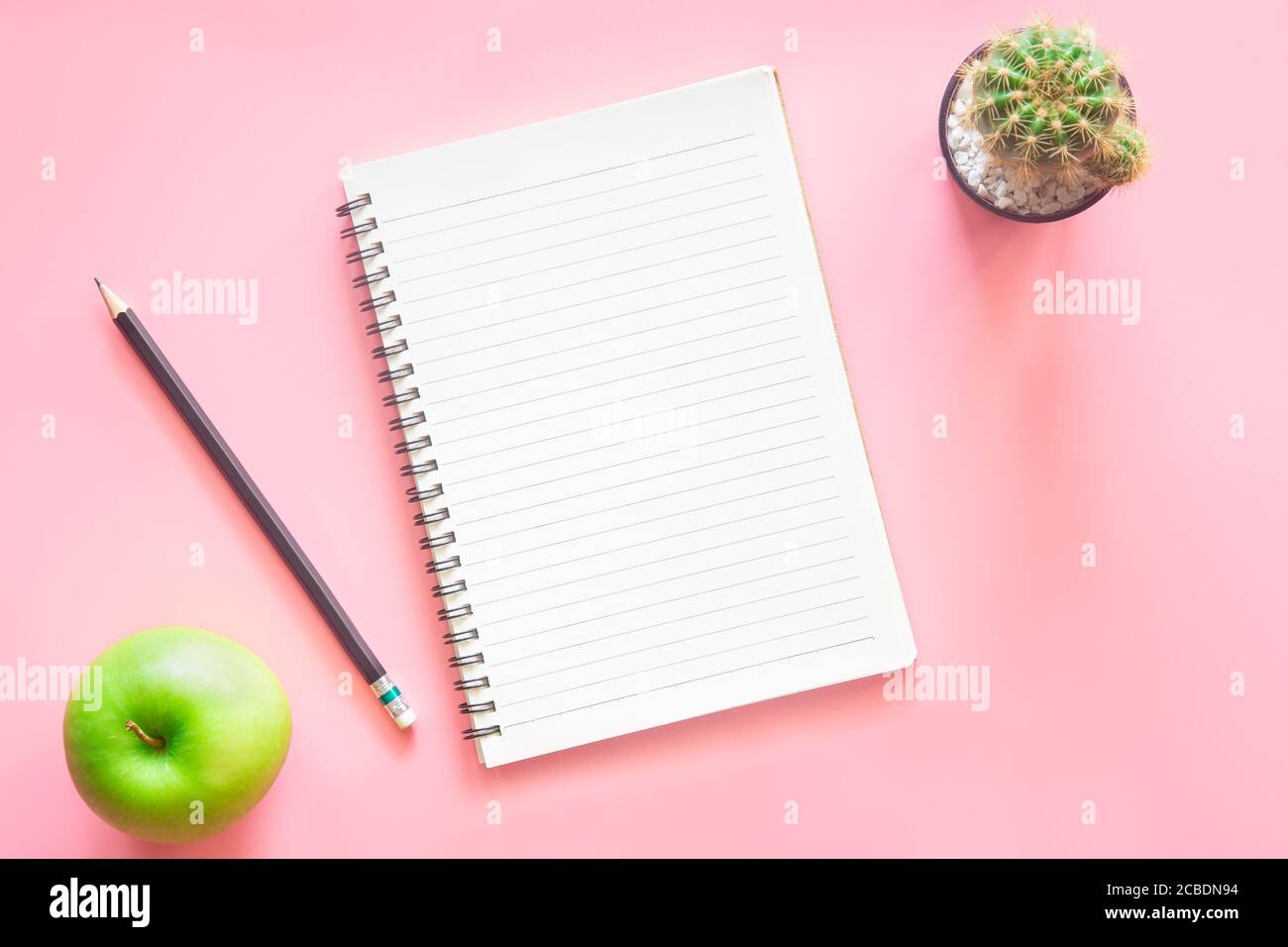 Pastel pink desk office with laptop, smartphone and other work supplies
