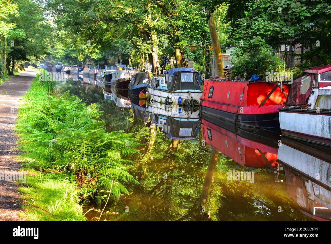 Narrowboats reflected in the Rochdale Canal, Hebden Bridge, Pennines, Yorkshire Stock Photo
