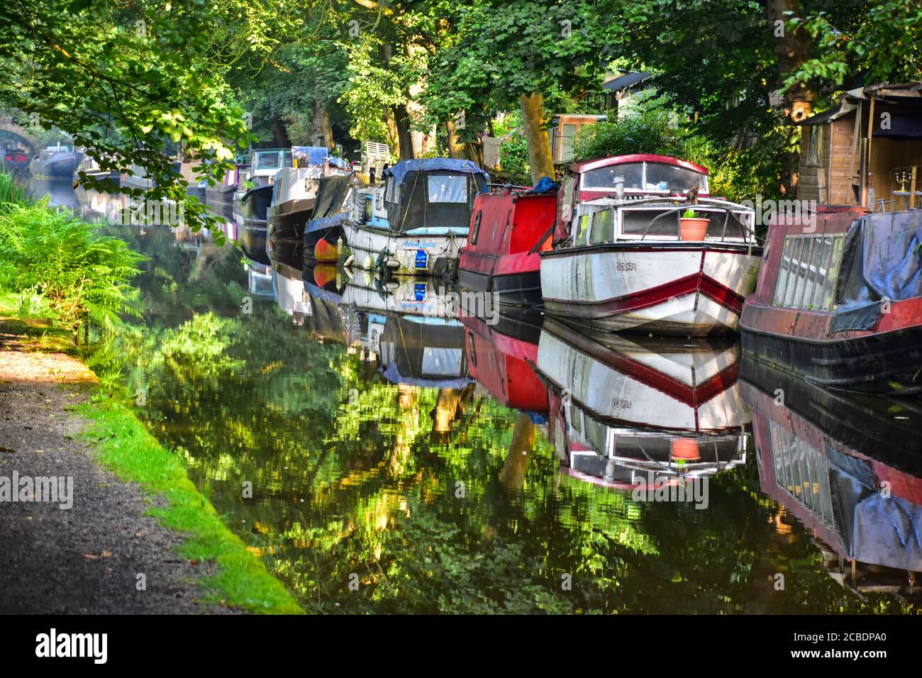Narrowboats reflected in the Rochdale Canal, Hebden Bridge, Pennines, Yorkshire Stock Photo