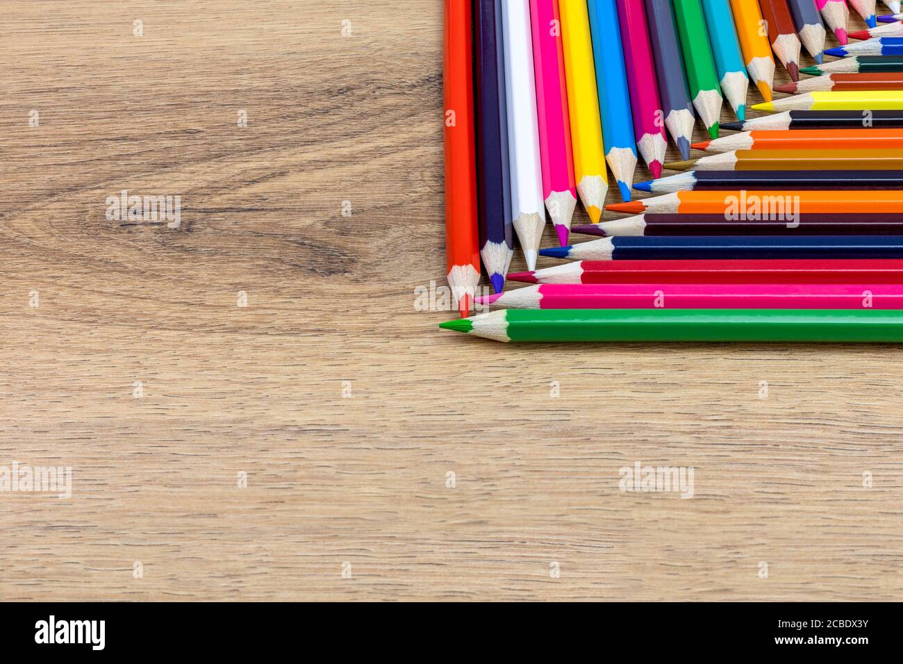 colored pencils aligned vertically and horizontally with crossed tips on the table Stock Photo