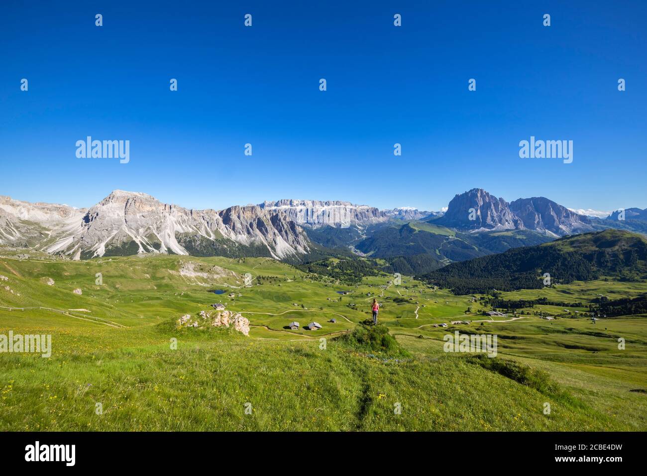 A woman observes mountains from Seceda, Gruppo delle Odle, Dolomiti di Gardena, Bolzano, Trentino Alto Adige, Italy, Southern Europe Stock Photo