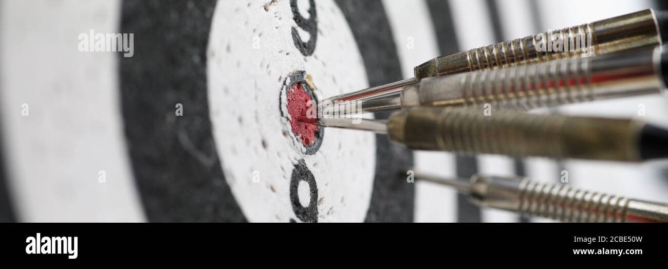 Metal darts sticking out in a dartboard target Stock Photo