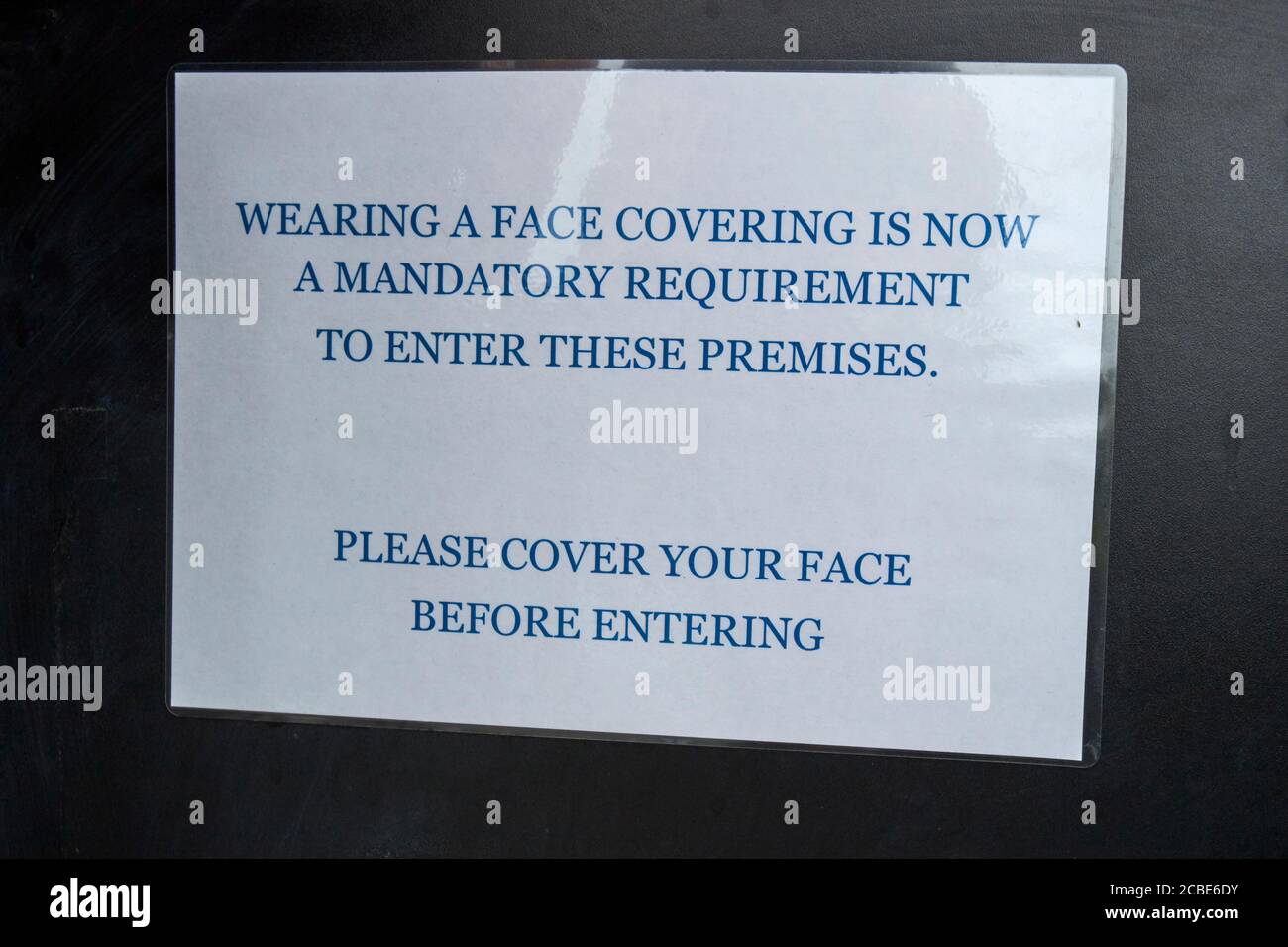 temporary notice about wearing face masks in a shop during the covid-19 coronavirus outbreak in the lake district cumbria england uk Stock Photo