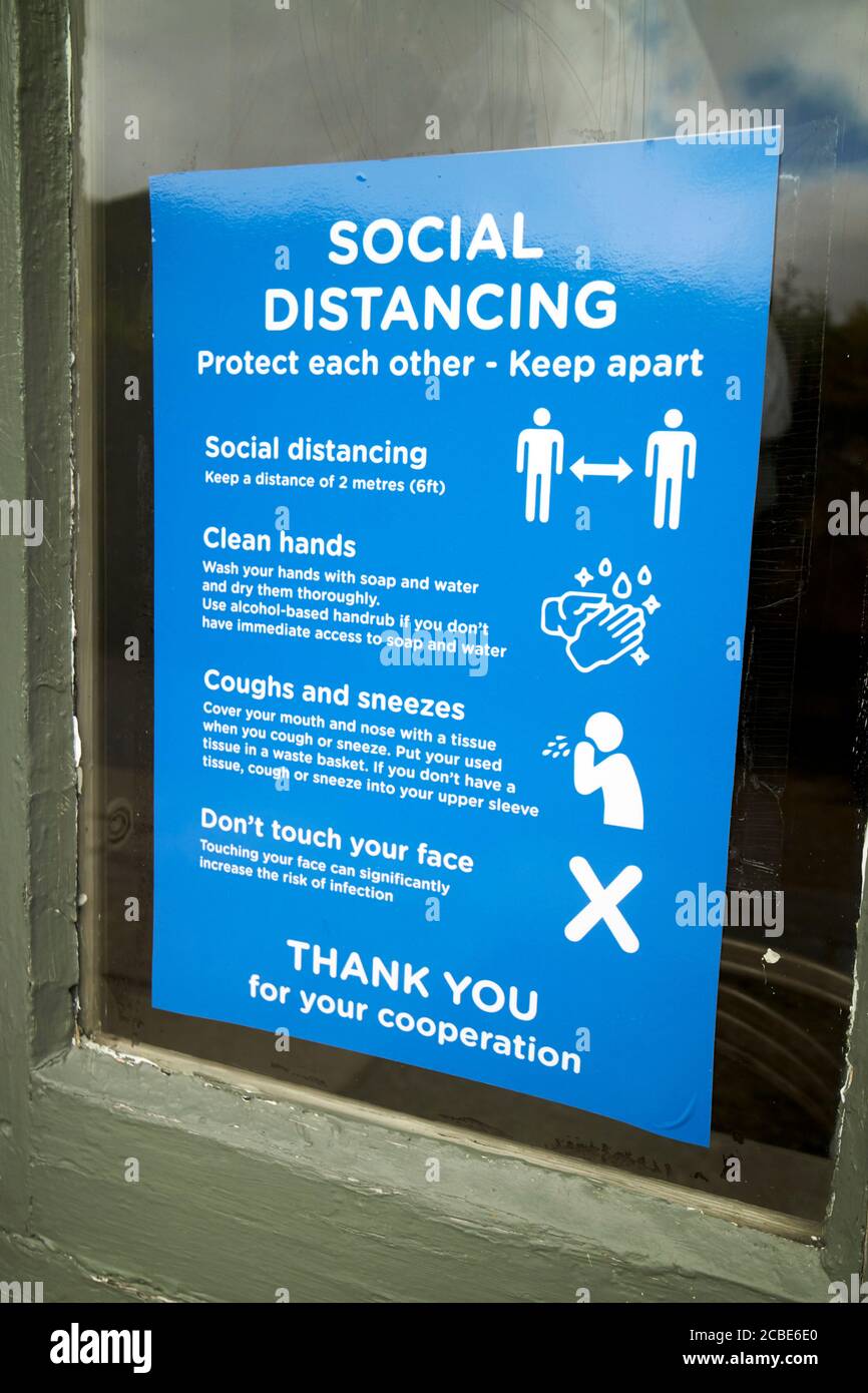 sign for measures put in place for social distancing during the covid-19 coronavirus outbreak in a shop in the lake district cumbria england uk Stock Photo