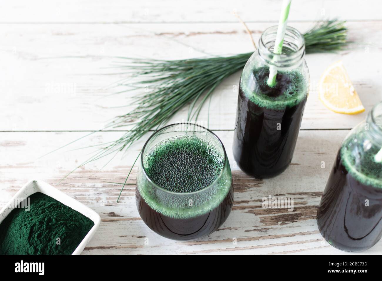 Spirulina drink and spirulina algae powder on white wooden table