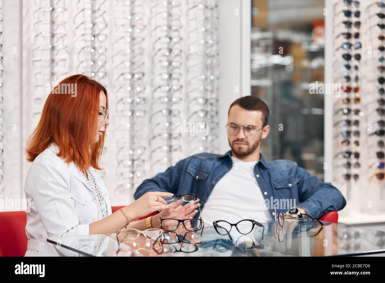 pensive thoughtful man looking at the glass table with eyeglasses while