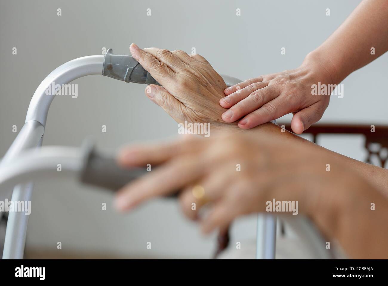 Elderly asian woman using a walker at home with caregiver take care Stock Photo