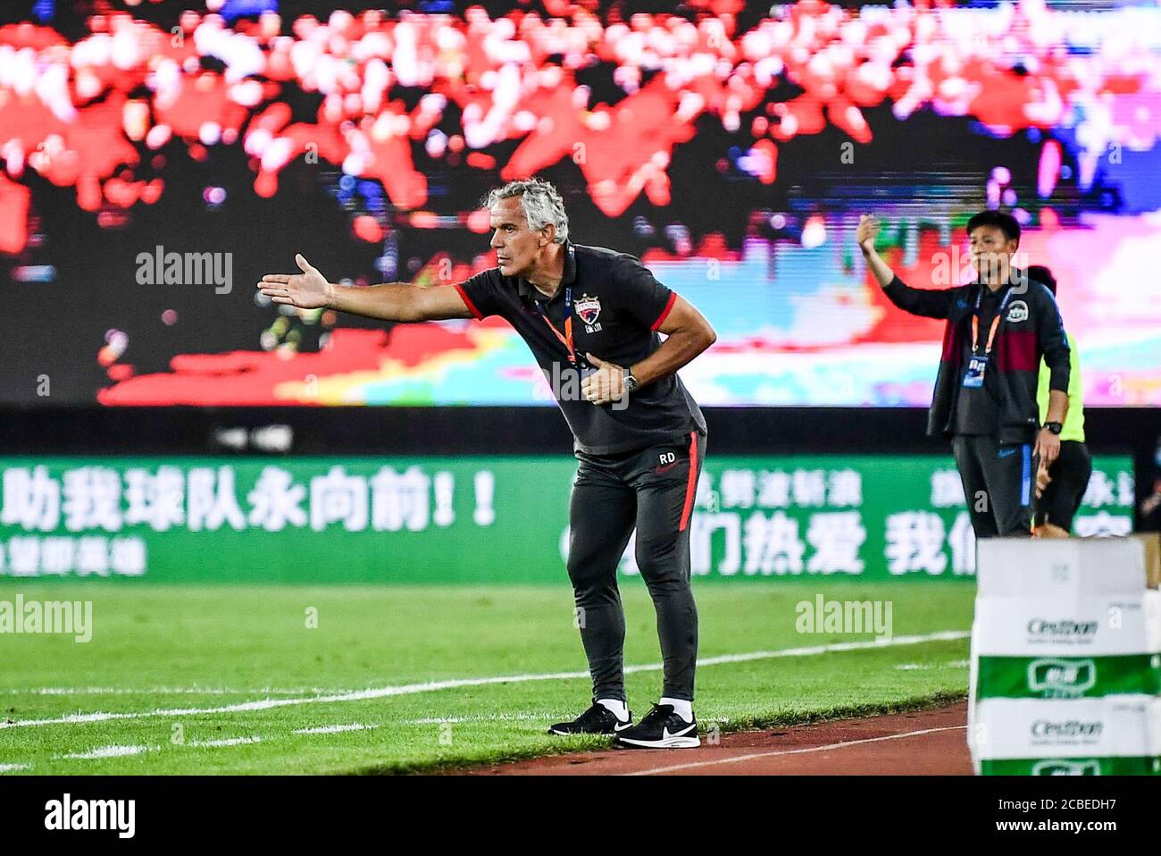 The head coach of Chinese club Shenzhen F.C. Roberto Donadoni, left, reacts during the fourth-round match of 2020 Chinese Super League (CSL) against Henan Jianye F.C., Dalian city, northeast China's Liaoning province, 10 August 2020. Shenzhen F.C. was defeated by Henan Jianye F.C. with 1-2. Stock Photo