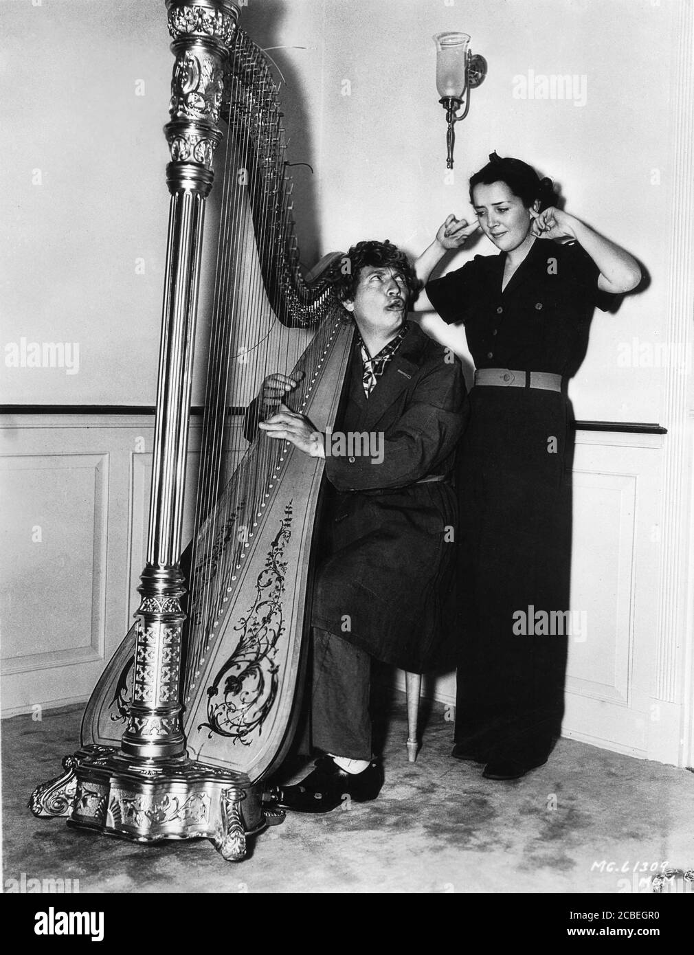 HARPO MARX and his Wife SUSAN FLEMING on set candid during filming of A  DAY AT THE RACES 1937 director SAM WOOD Metro Goldwyn Mayer Stock Photo