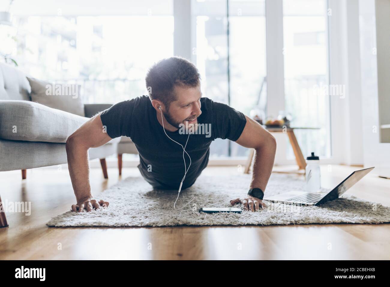 Handsome young man working out at home in the living room Stock Photo