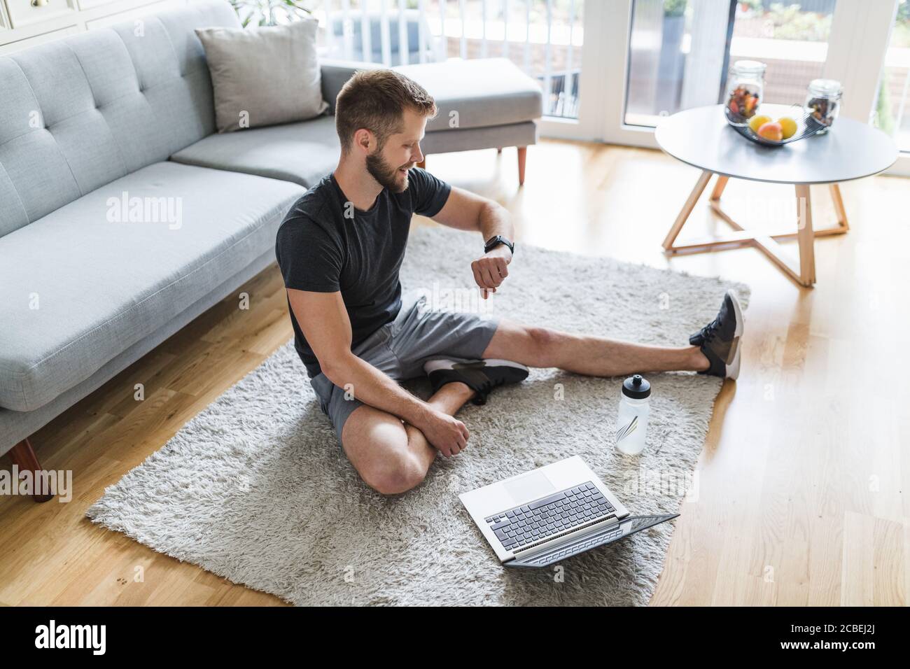 Handsome young man working out at home in the living room Stock Photo