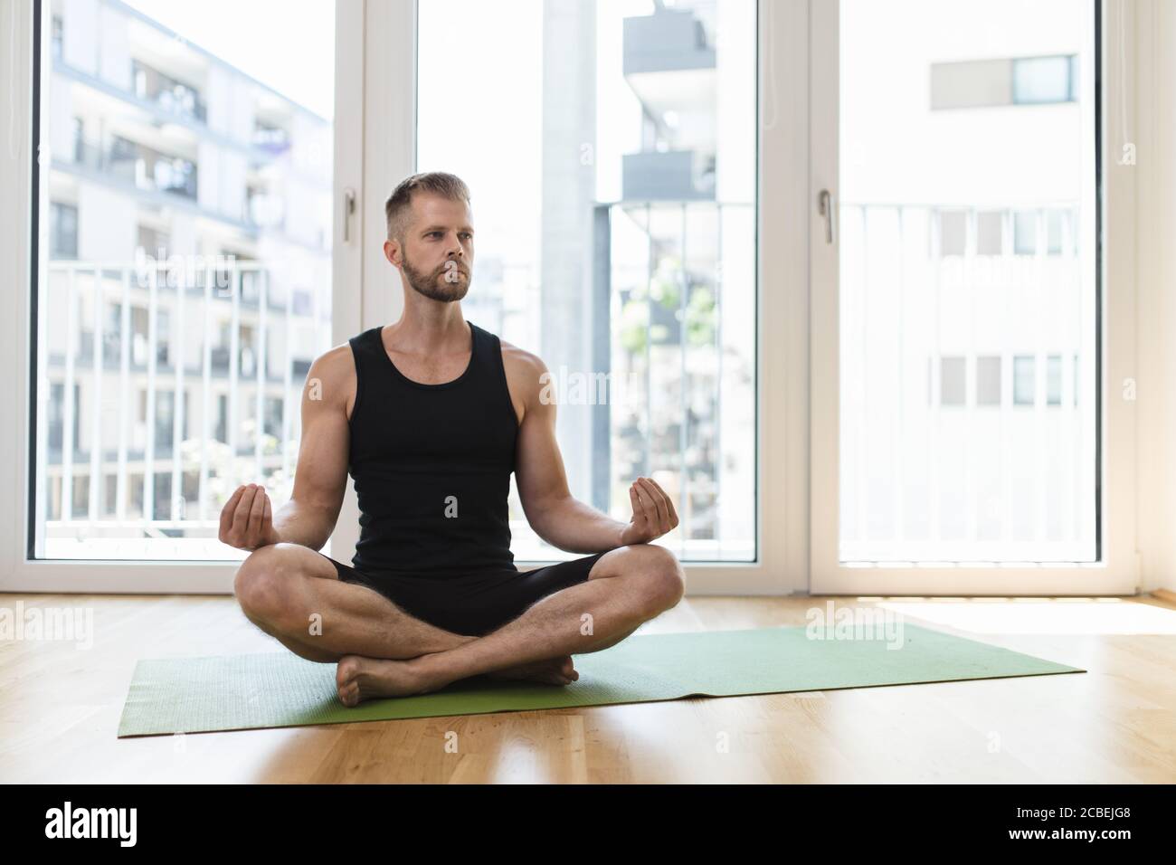 Young handsome man practicing yoga at home Stock Photo