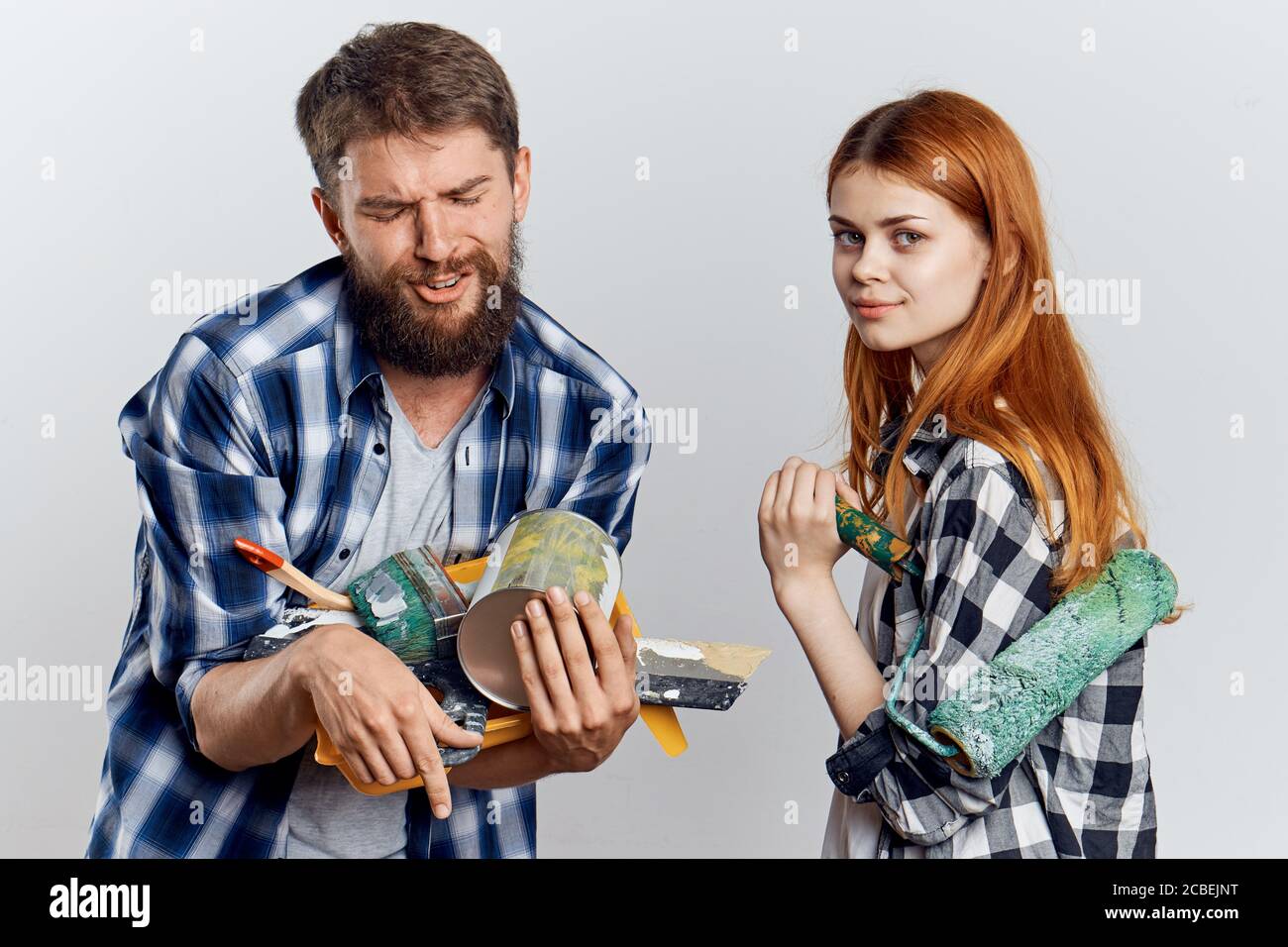 family young couple in plaid shirts repairing construction tools Stock Photo