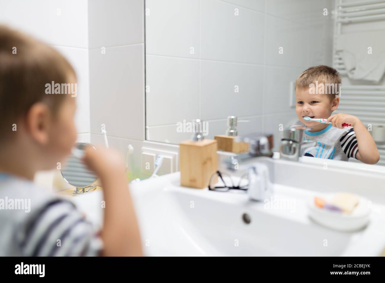 Adorable child brushing his teeth in the bathroom Stock Photo