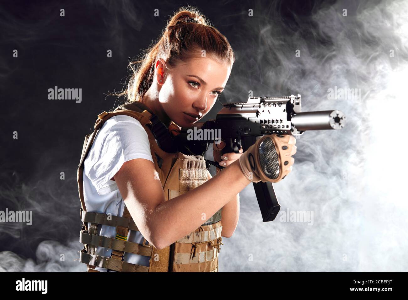 Calm concentrated woman marksman in sniper gear holding rifle in hand