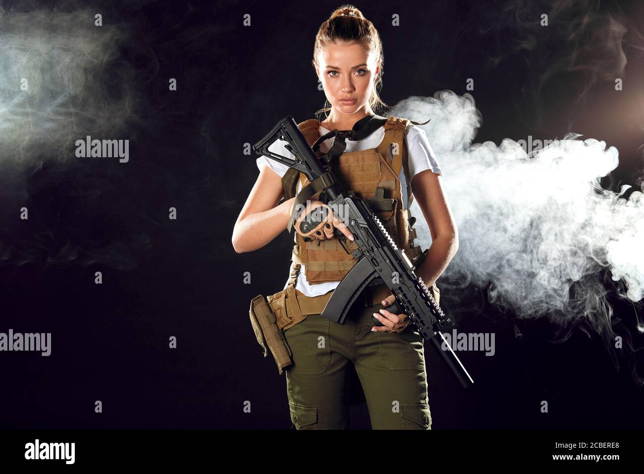 Woman in the army pros and cons. Women do not just serve, but attain high positions and ranks. Beautiful woman in military outfitholding weapon in han Stock Photo