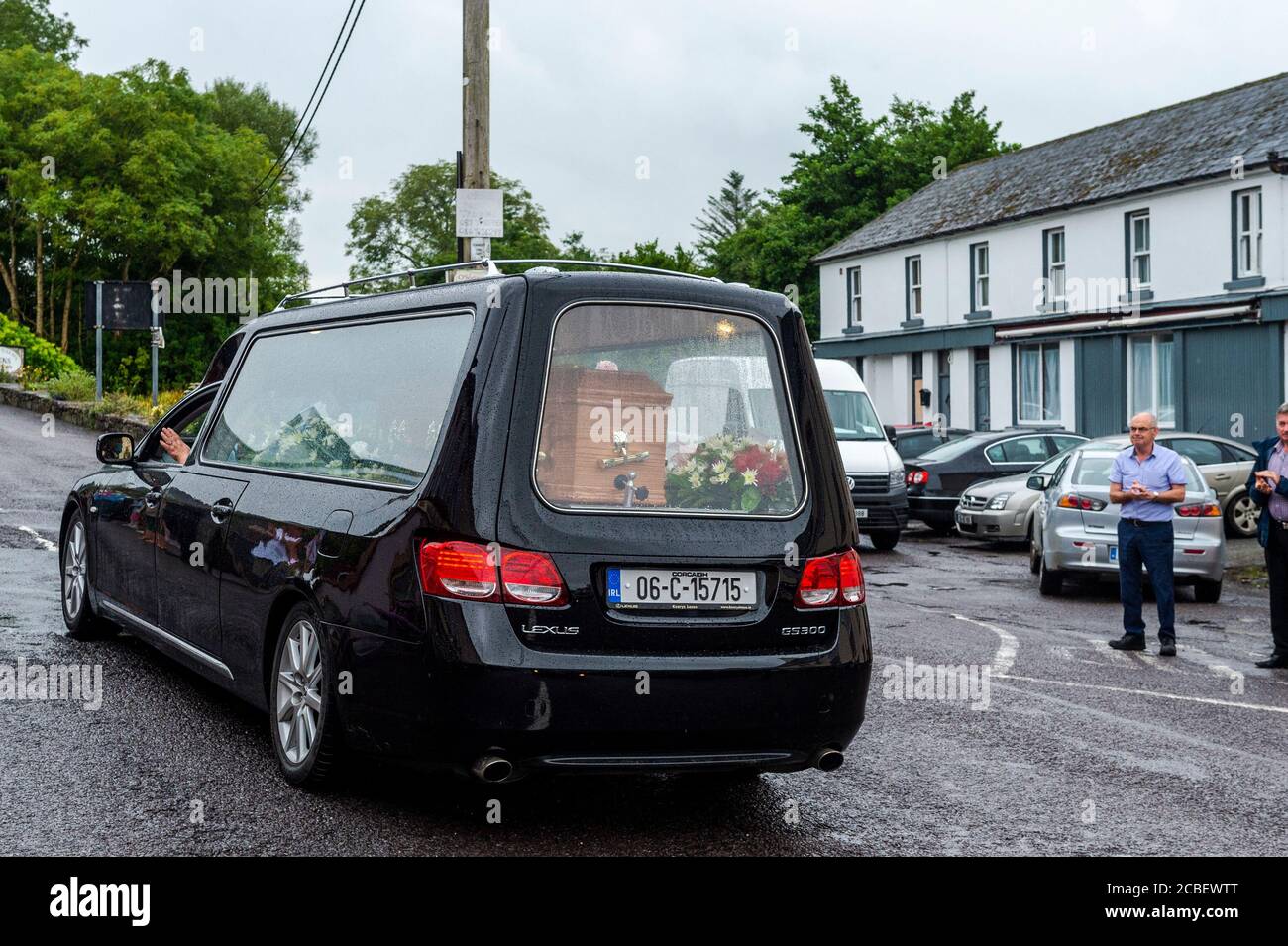 Durrus, West Cork, Ireland. 13th Aug, 2020. Ex Fine Gael TD Paddy Sheehan's funeral cortege passes through Durrus on its way to Mr. Sheehan's funeral service in Goleen, West Cork.  Around 50 people turned out to say a last goodbye to Mr. Sheehan, with people breaking into a round of applause as the hearse containing Mr. Sheehan's coffin passed. Credit: AG News/Alamy Live News Stock Photo