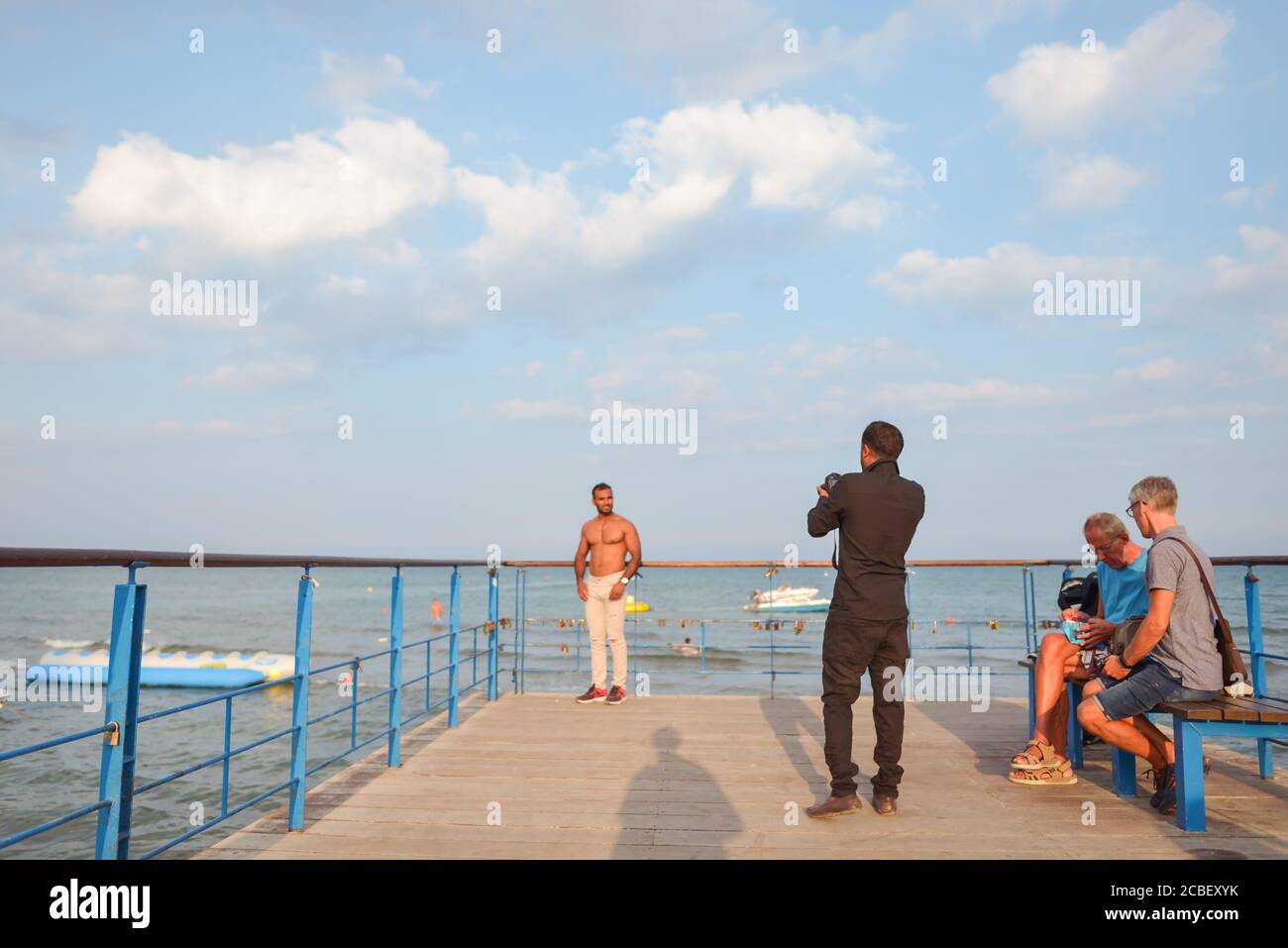 Larnaca / Cyprus - August 15, 2019: tourists taking pictures on the pier on Larnaca beach Stock Photo