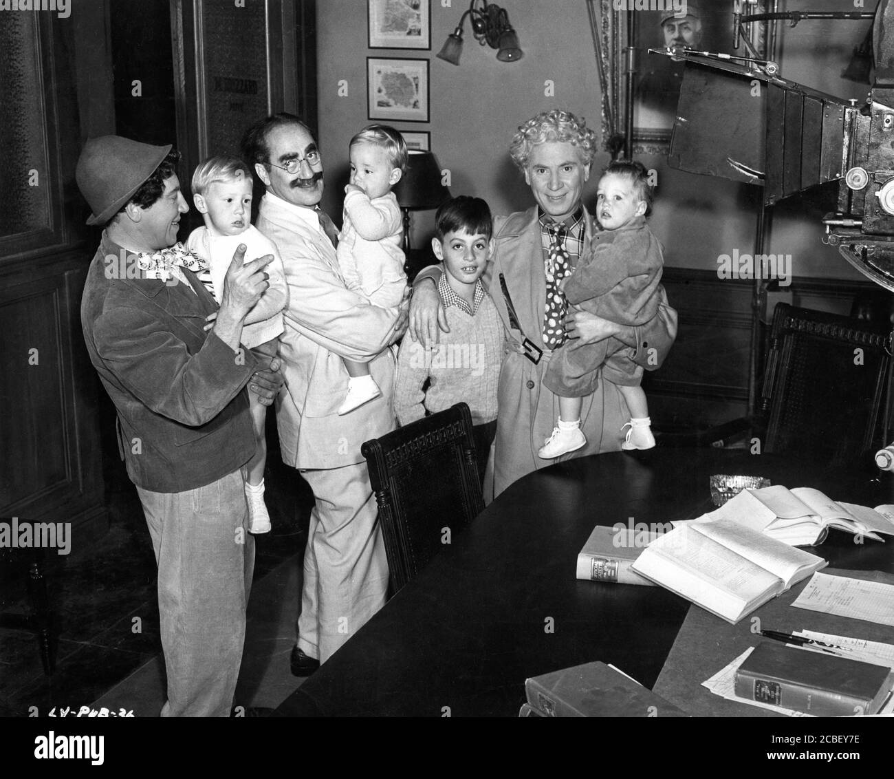 CHICO MARX GROUCHO MARX and HARPO MARX on set candid with Harpo's 4 adopted children MINNIE, JIMMIE, BILLY WOOLLCOTT and ALEXANDER during filming of A NIGHT IN CASABLANCA 1946 director ARCHIE L. MAYO producer David L. Loew Loma Vista Productions / United Artists Stock Photo