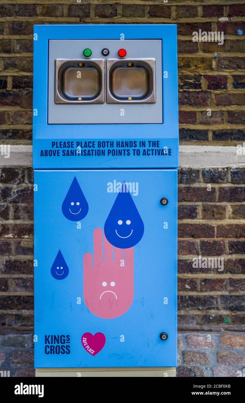Automatic Hand Sanitiser machine at London Kings Cross - automatically sprays sanitiser when hands are inserted into the slots. Stock Photo