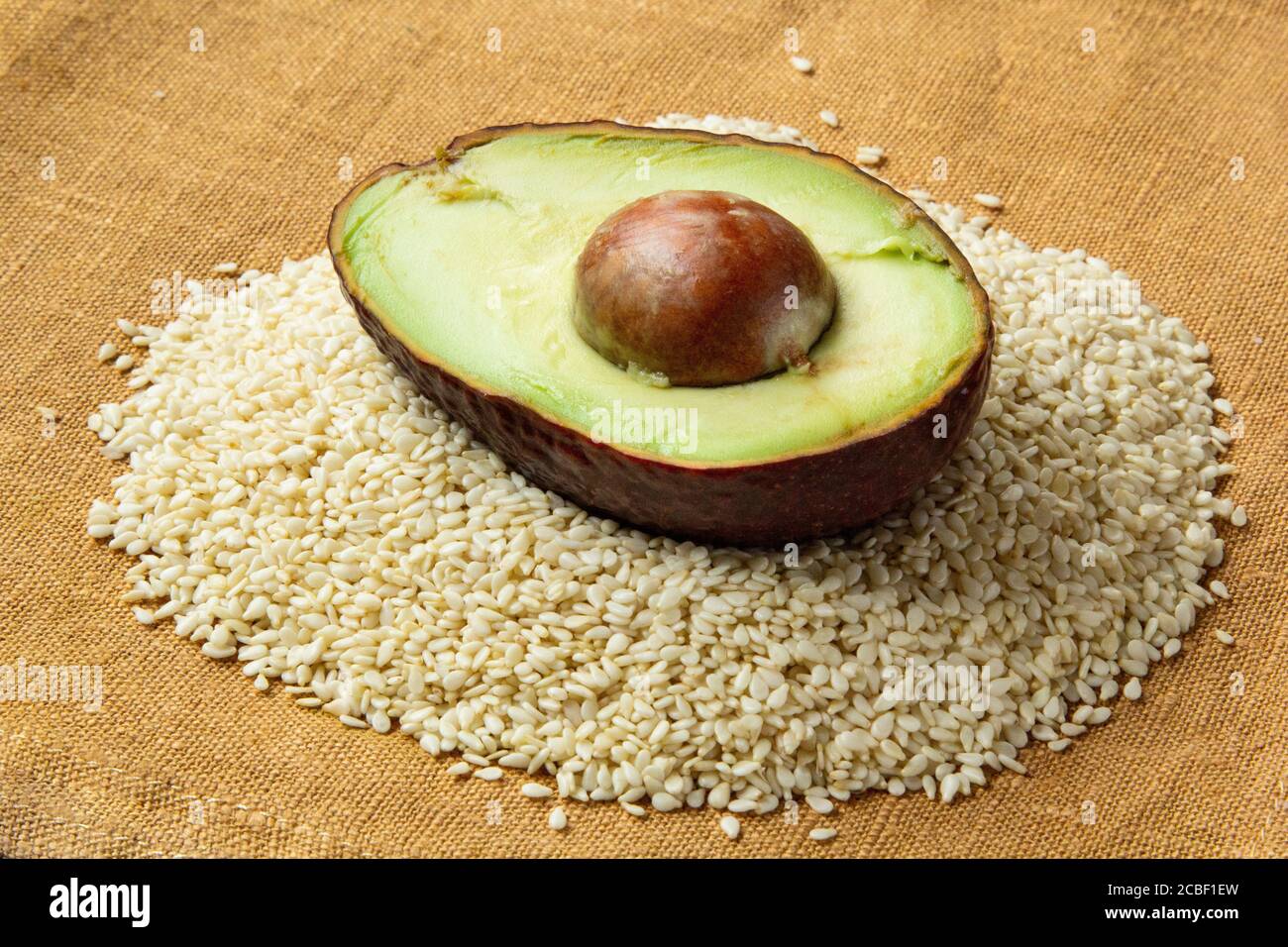 Hulf of avocado on sesame seeds. food ingredient preparation for
