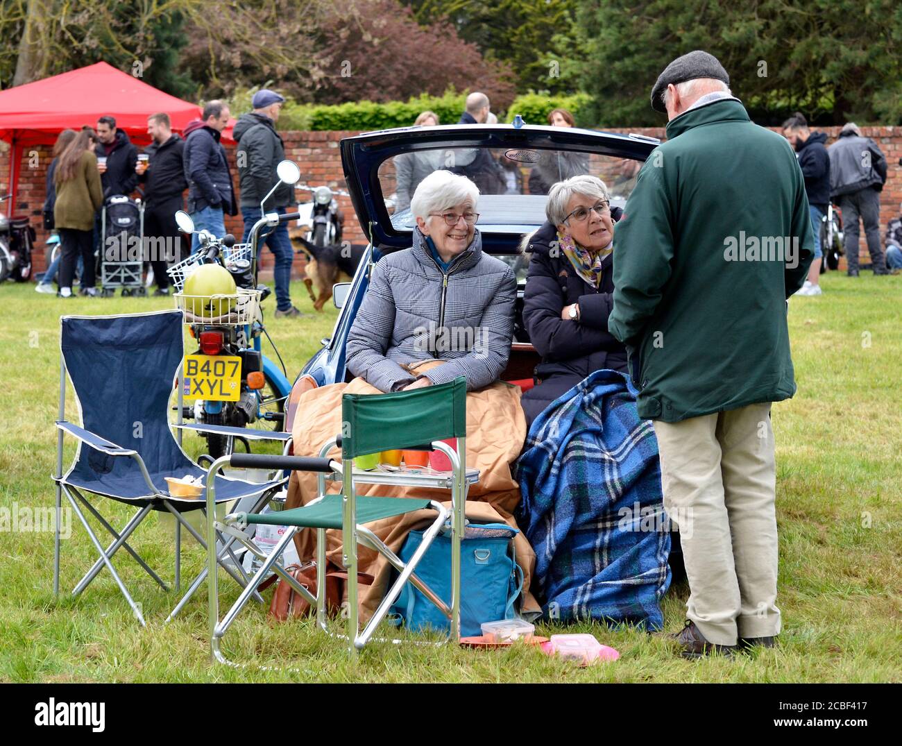 two women keeping warm at classic car rally Stock Photo
