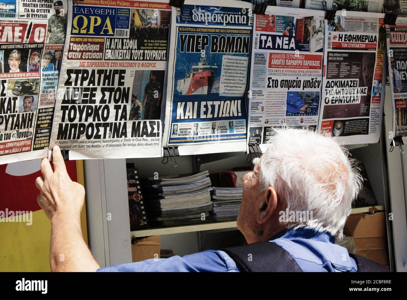 Greece, Athens, August 11 2020 - People reading the news at a press kiosk in the center of Athens, on a day of high tension between Greece and Turkey, Stock Photo
