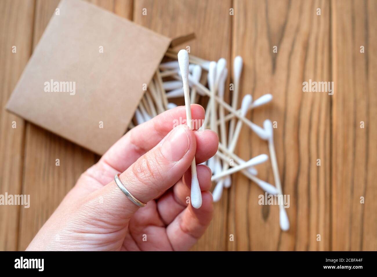 Cotton swab in hand. Eco-friendly ear cleaning and beauty stick. Stock Photo