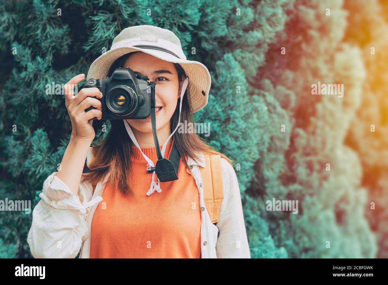 Pritty young Asian photographer girl teen travel with camera trip take a photo tourist lifestyle standing smile with hat Stock Photo
