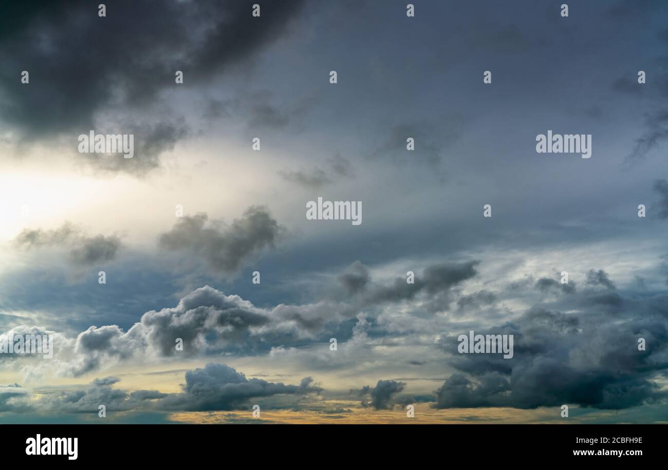 Sunset sky and gray and golden clouds. Gray sky and fluffy clouds. Thunder and storm sky. Sad and moody sky. Dead abstract background. Cloudscape. Stock Photo