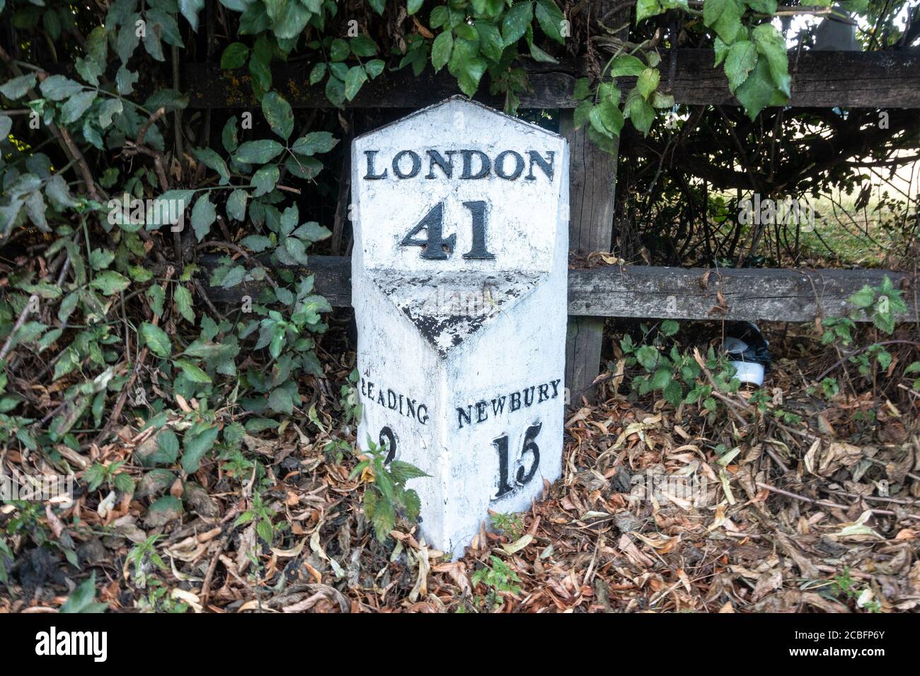 A milepost on the side of The Bath Road in Reading, Berkshire gives distances to London, Newbury and the centre of Reading. Stock Photo