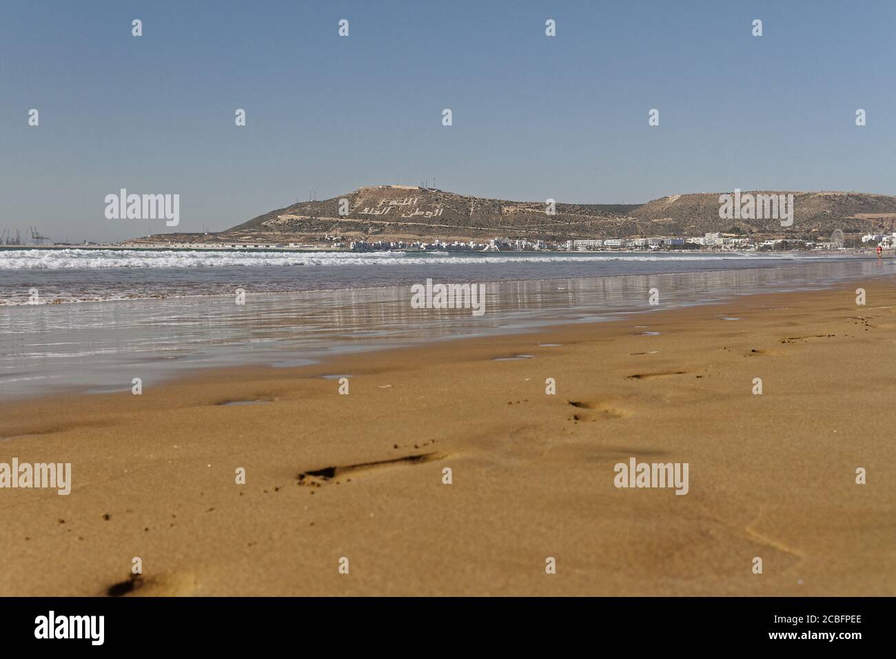 Agadir, Morocco.Feb.3,2019:Beach with tourist walking and Moroccan motto on  the mountain. Writing on the hillside meaning, God, Country, King. People  Stock Photo - Alamy