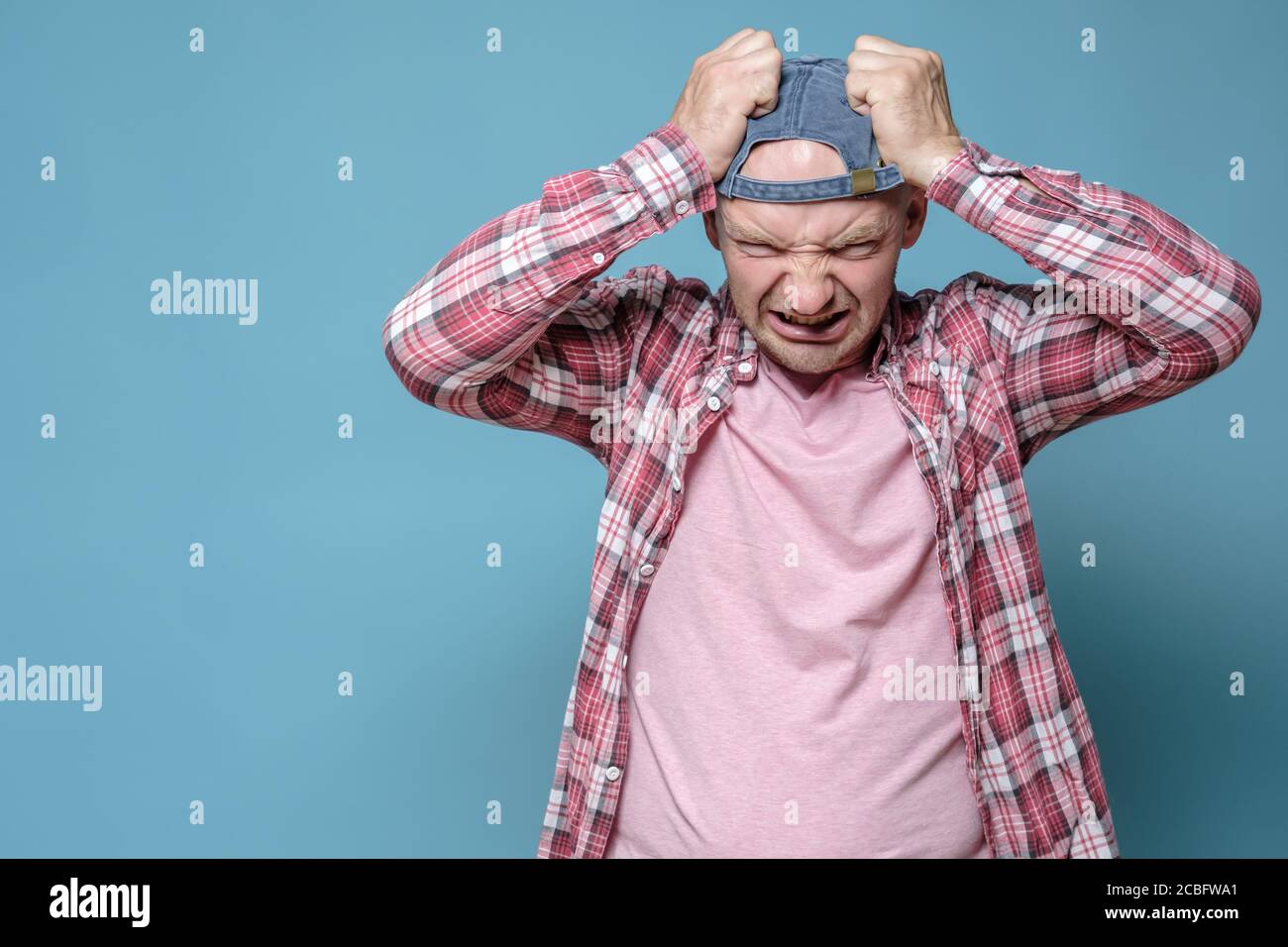 Irritation, furious Caucasian male man nervously grabs his head. Copy space. Psychological health concept.  Stock Photo