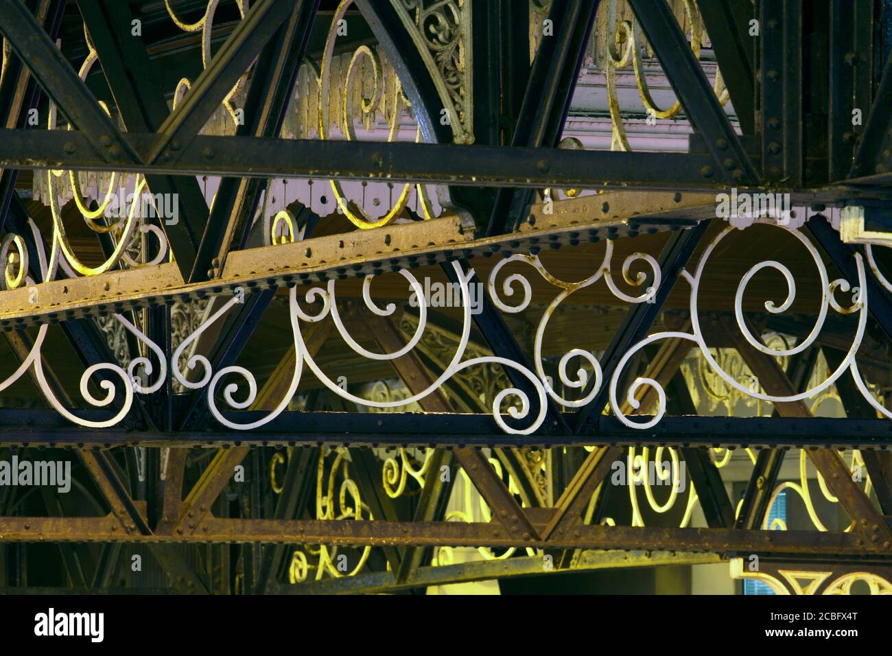 Close up of the flamboyant ironwork in the canopy over the entrance to Brighton station. (Photographed at night with station lighting.) Stock Photo