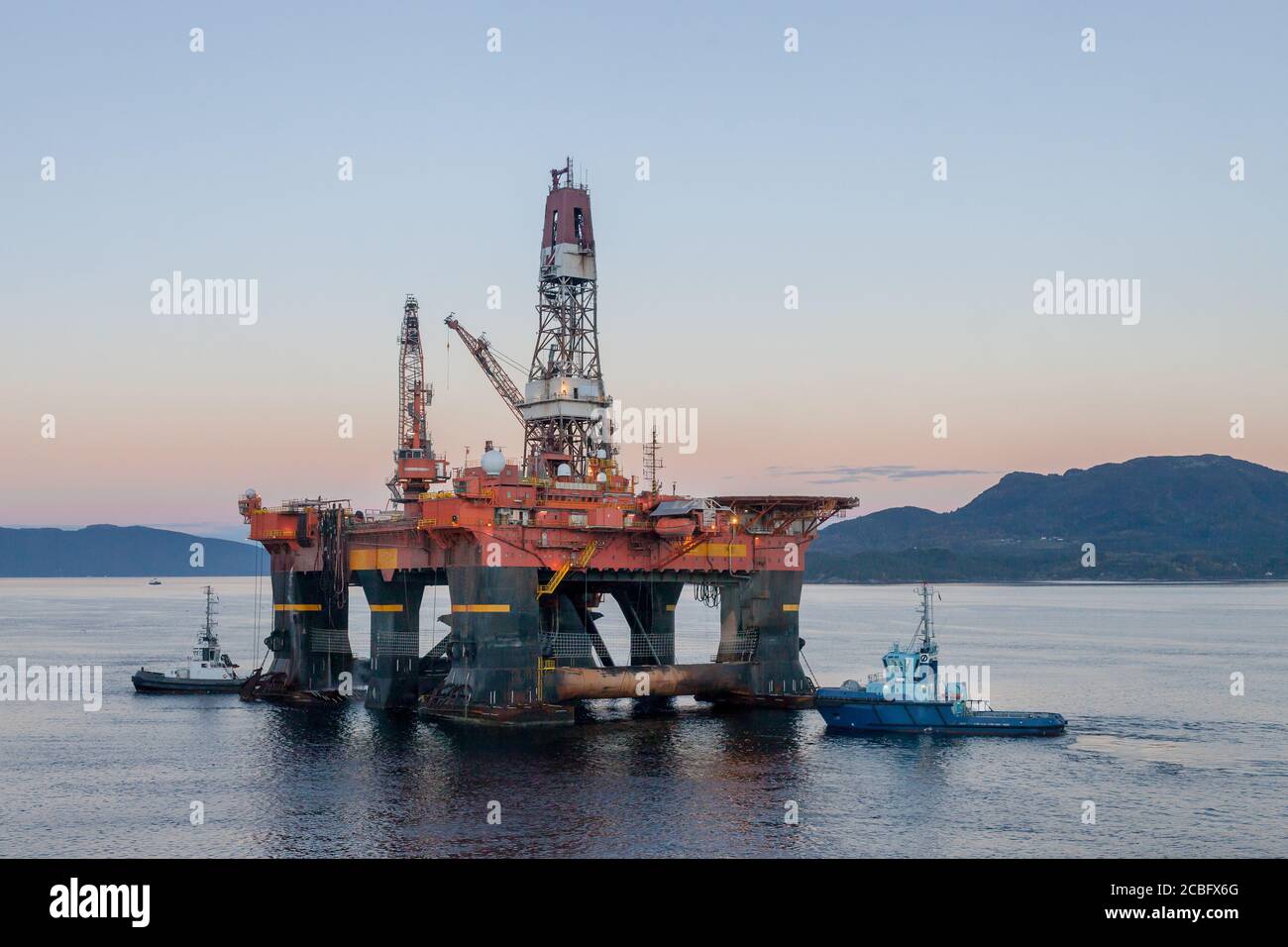 OELEN NORWAY - 2014 OCTOBER 16. The semi-submersible drilling rig West Alpha inside the Norwegian fjord in the morning with tug boats. Stock Photo