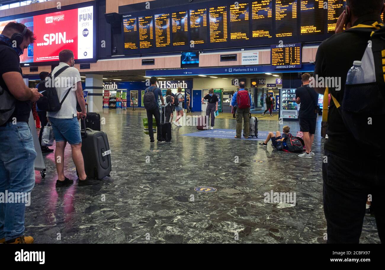 Passengers waiting for trains on Euston station during Covid facemask regulations Stock Photo